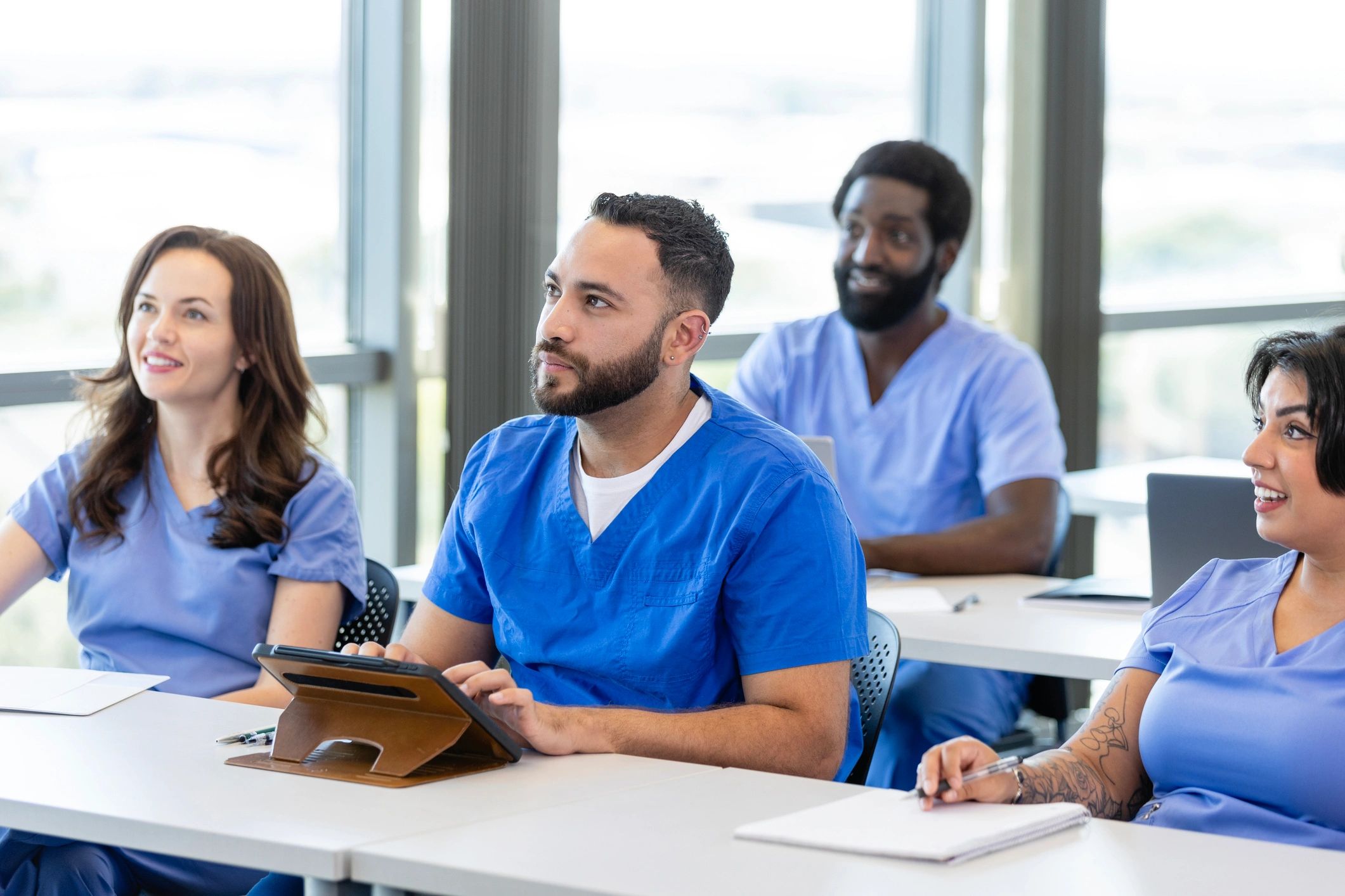 Healthcare workers in a meeting listening and taking notes